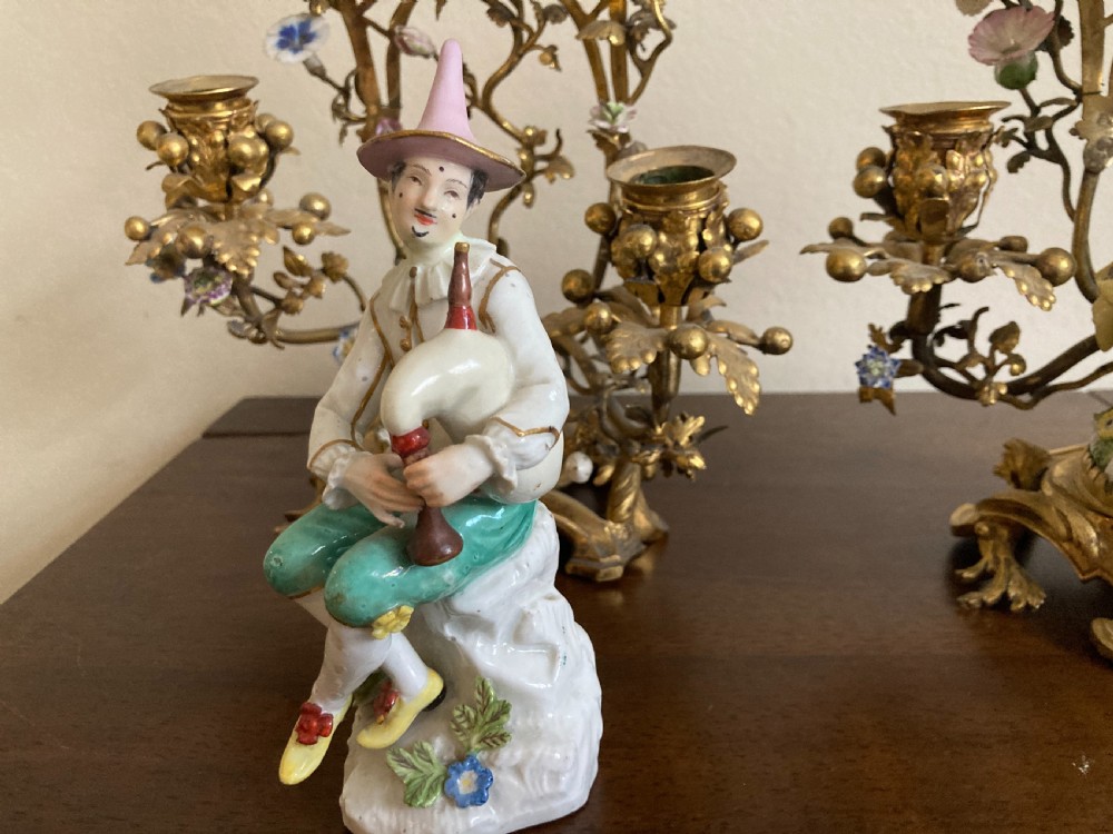 A pair of 18th-century Rococo gilt bronze candelabra featuring seated Meissen porcelain musician figures against floral trellis backdrops. View IX