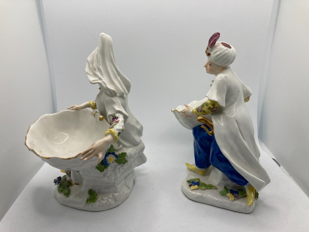 A pair of 18th-century Meissen hard-paste porcelain figures wearing Ottoman garments, each holding a scallop shell-shaped dish. View X