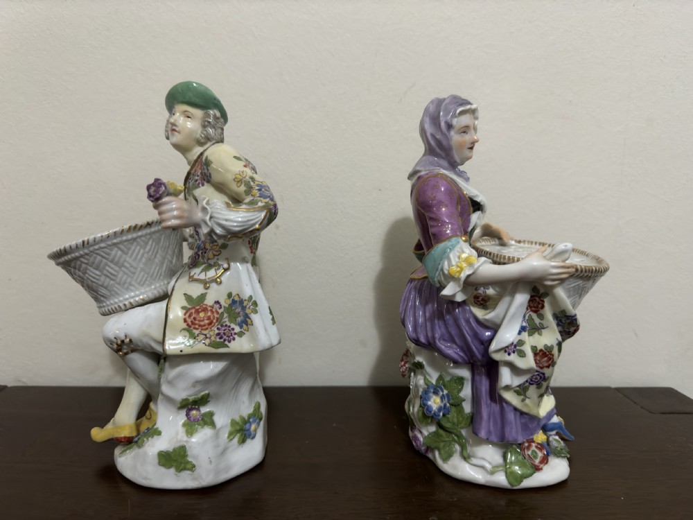 A pair of 18th-century Meissen hard-paste porcelain figures of a seated man and woman holding lattice-patterned basket flower holders with pierced tops. View III