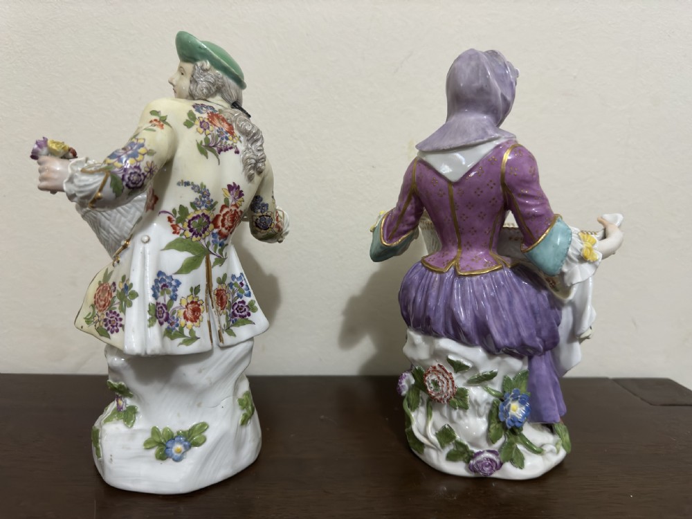 A pair of 18th-century Meissen hard-paste porcelain figures of a seated man and woman holding lattice-patterned basket flower holders with pierced tops. View V