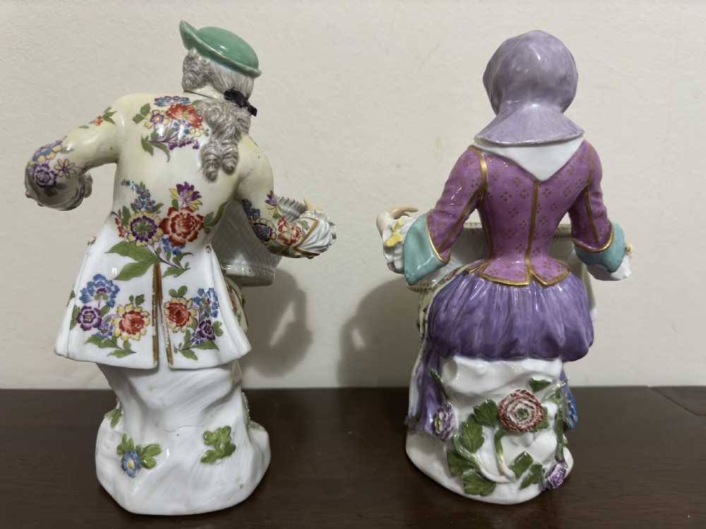 A pair of 18th-century Meissen hard-paste porcelain figures of a seated man and woman holding lattice-patterned basket flower holders with pierced tops. View VI