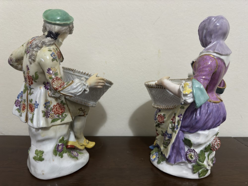 A pair of 18th-century Meissen hard-paste porcelain figures of a seated man and woman holding lattice-patterned basket flower holders with pierced tops. View VII