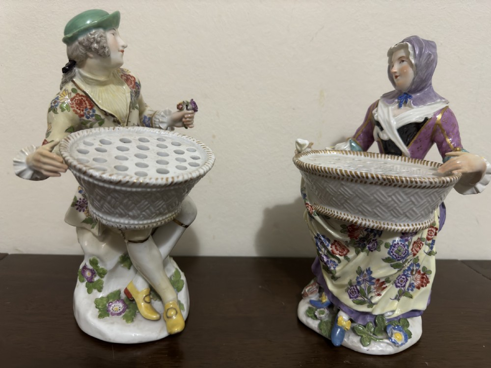 A pair of 18th-century Meissen hard-paste porcelain figures of a seated man and woman holding lattice-patterned basket flower holders with pierced tops. View IX