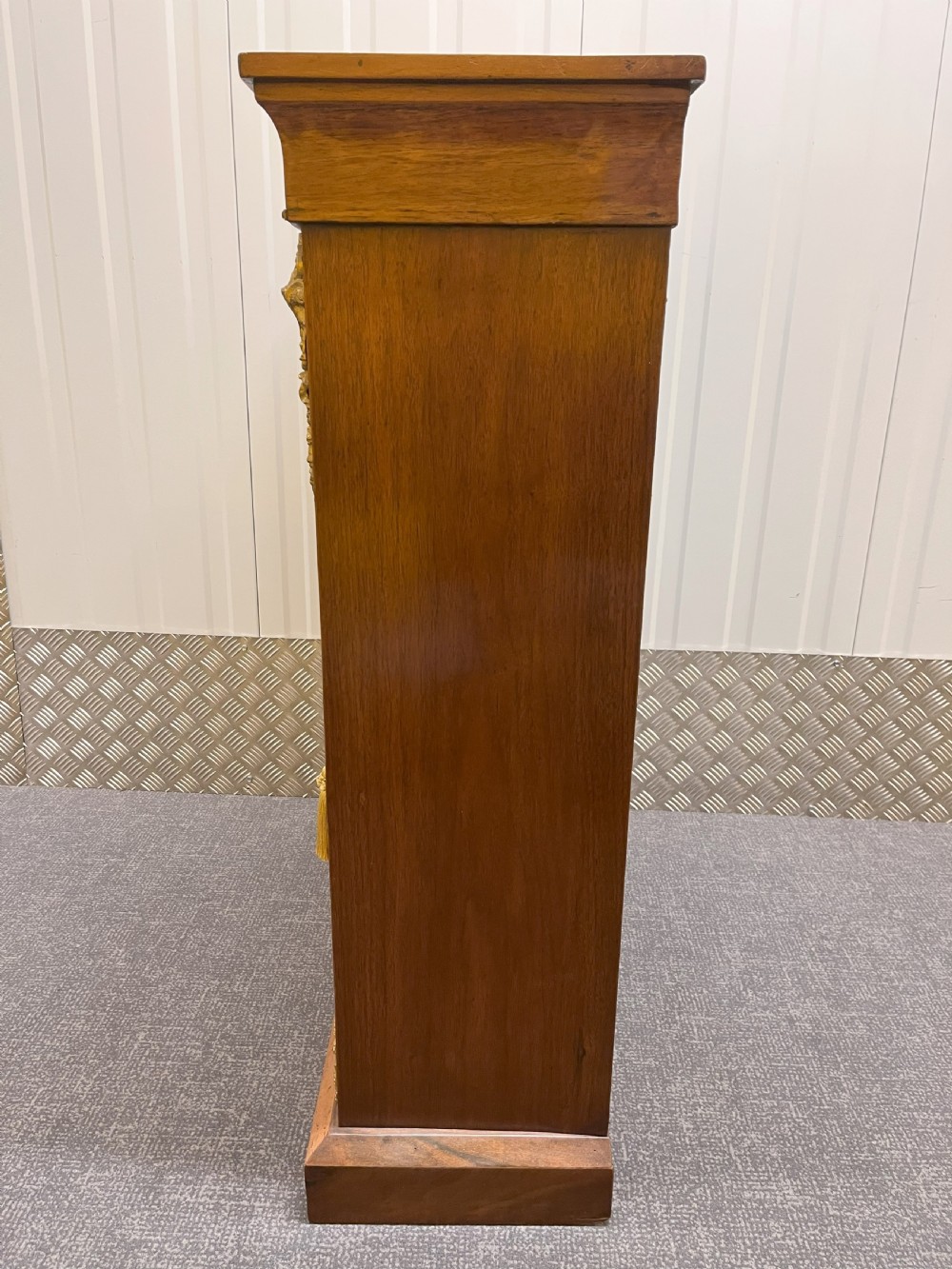 A Regency rosewood side cabinet featuring a brass lattice door with pleated fabric backing, ornate brass mounts, and brass marquetry inlays. View VII