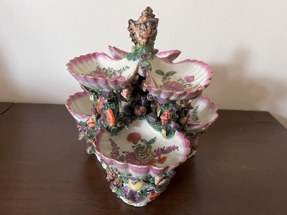 A multi-tiered 18th-century porcelain sweetmeat stand composed of shell-shaped dishes supported by a column encrusted with miniature shells and painted with floral motifs. View II