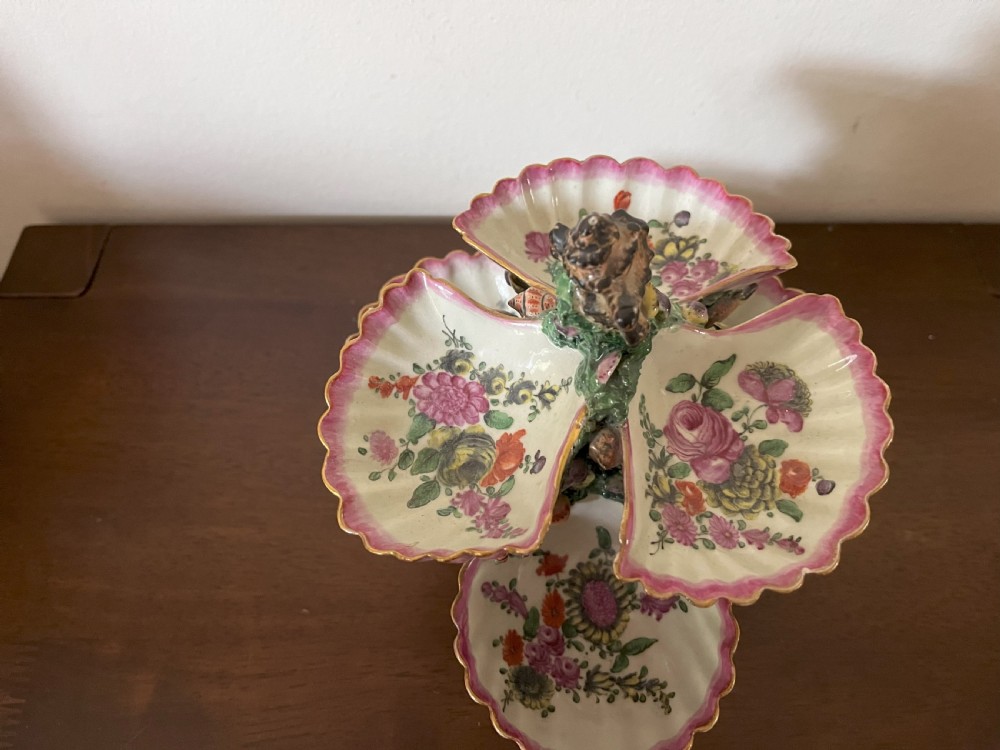 A multi-tiered 18th-century porcelain sweetmeat stand composed of shell-shaped dishes supported by a column encrusted with miniature shells and painted with floral motifs. View VIII