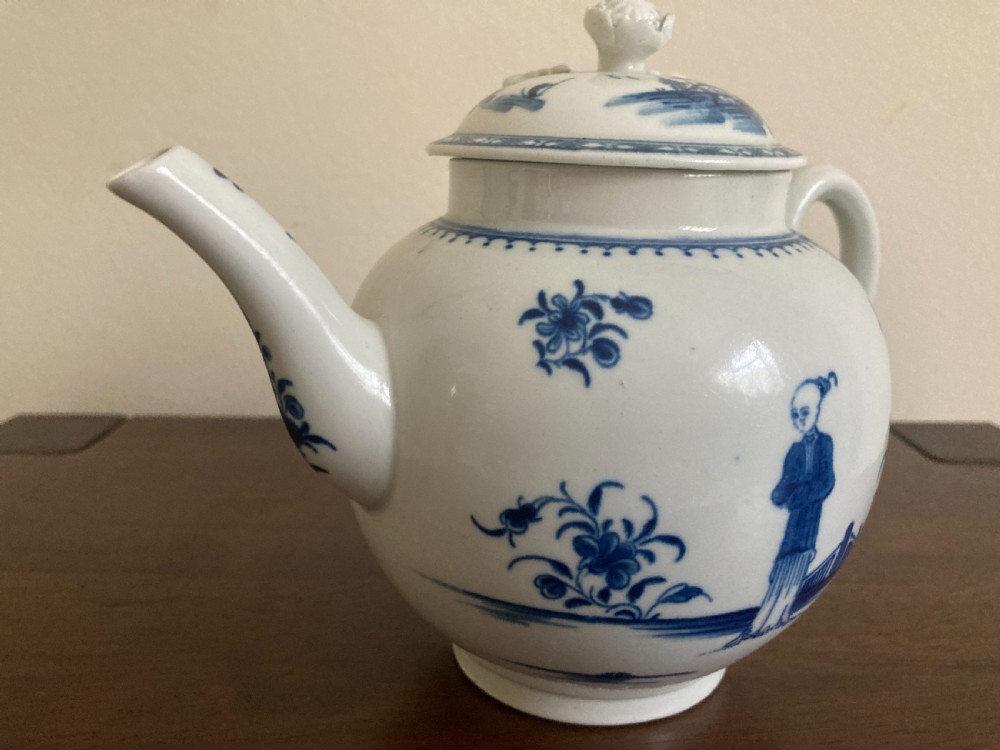 An 18th-century First Period Worcester blue and white soft-paste porcelain teapot featuring a painted chinoiserie figure, domed lid, and floral knop. View II