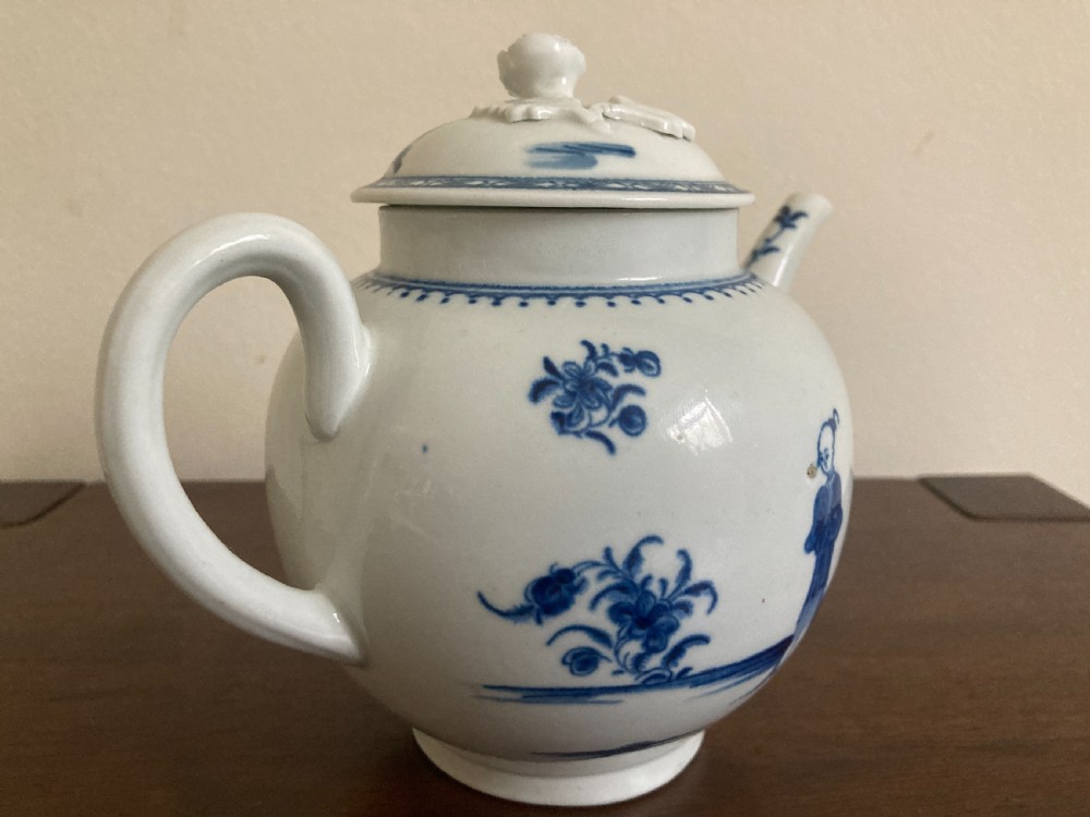 An 18th-century First Period Worcester blue and white soft-paste porcelain teapot featuring a painted chinoiserie figure, domed lid, and floral knop. View VII