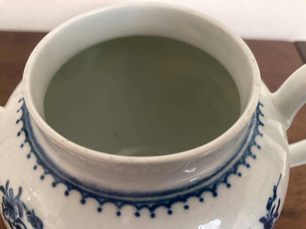 An 18th-century First Period Worcester blue and white soft-paste porcelain teapot featuring a painted chinoiserie figure, domed lid, and floral knop. View XIII