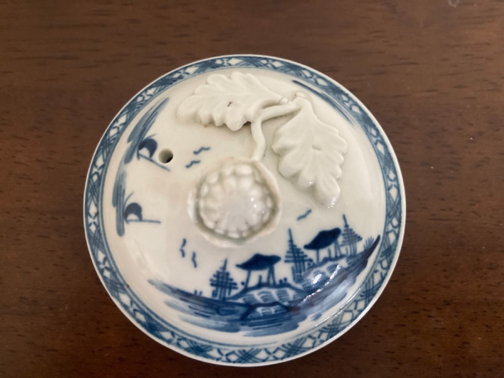 An 18th-century First Period Worcester blue and white soft-paste porcelain teapot featuring a painted chinoiserie figure, domed lid, and floral knop. View XV