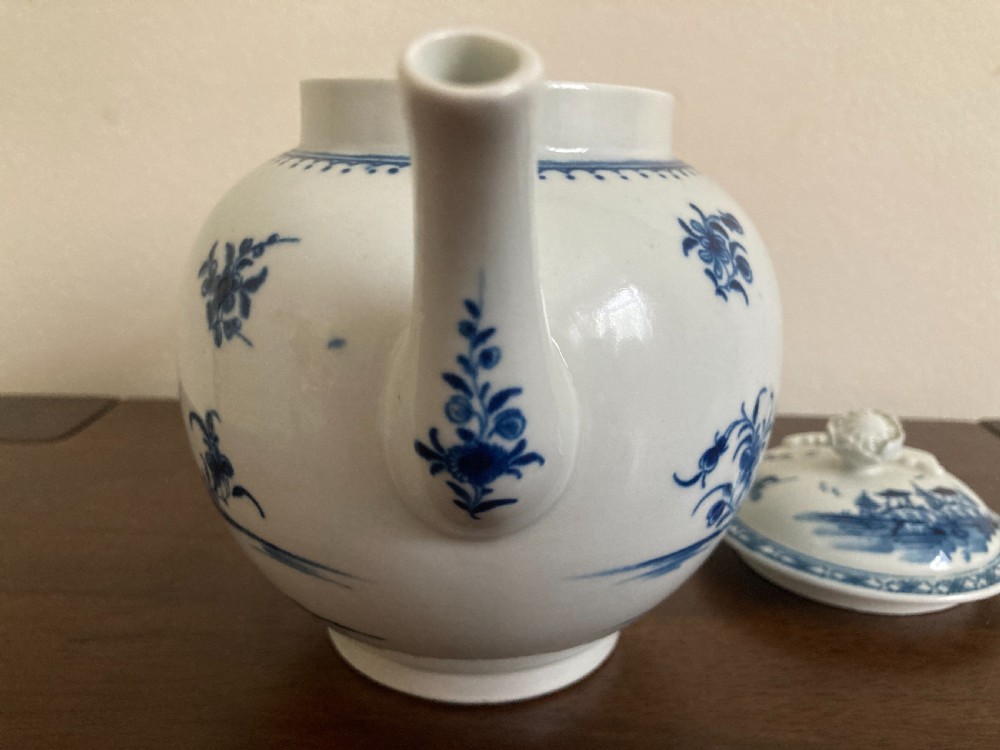 An 18th-century First Period Worcester blue and white soft-paste porcelain teapot featuring a painted chinoiserie figure, domed lid, and floral knop. View XVII