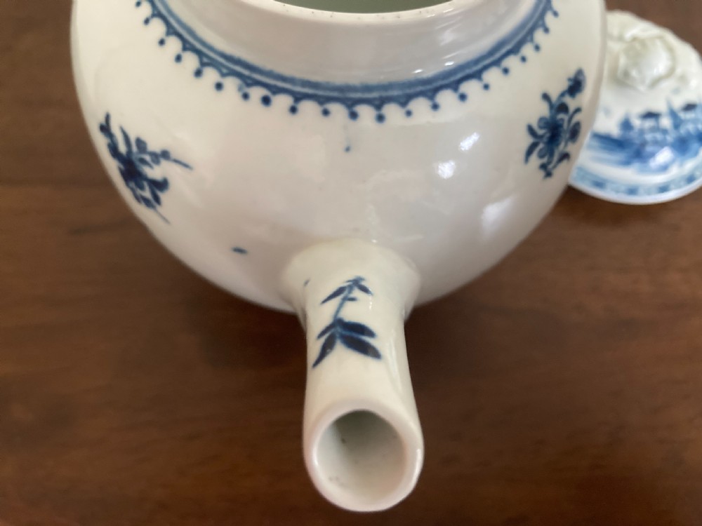 An 18th-century First Period Worcester blue and white soft-paste porcelain teapot featuring a painted chinoiserie figure, domed lid, and floral knop. View XVIII