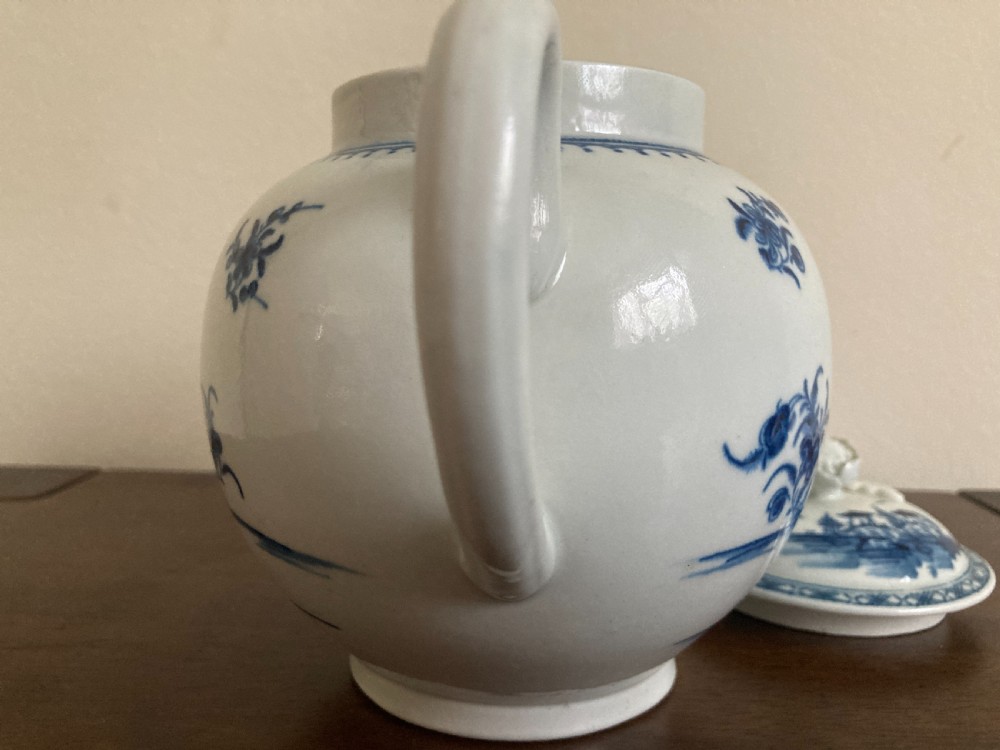 An 18th-century First Period Worcester blue and white soft-paste porcelain teapot featuring a painted chinoiserie figure, domed lid, and floral knop. View XIX