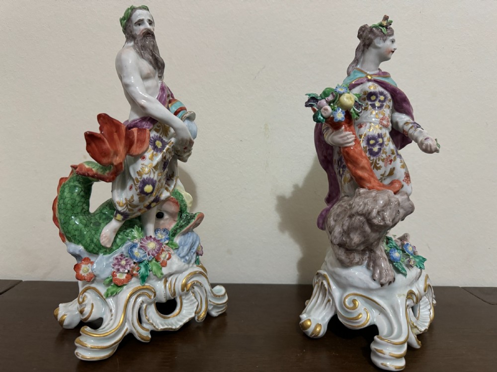 A pair of 18th-century polychrome porcelain allegorical figures depicting Water and Land resting on gilded Rococo scroll bases. View X