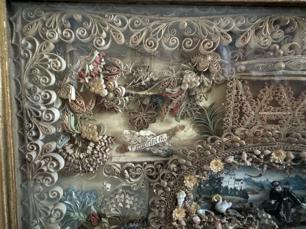An 18th-century French giltwood framed shadow box containing intricate paperoles scrollwork surrounding a central miniature landscape with Nevers glass figures. View III