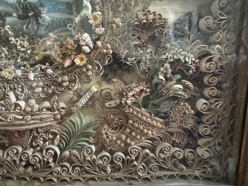 An 18th-century French giltwood framed shadow box containing intricate paperoles scrollwork surrounding a central miniature landscape with Nevers glass figures. View VI
