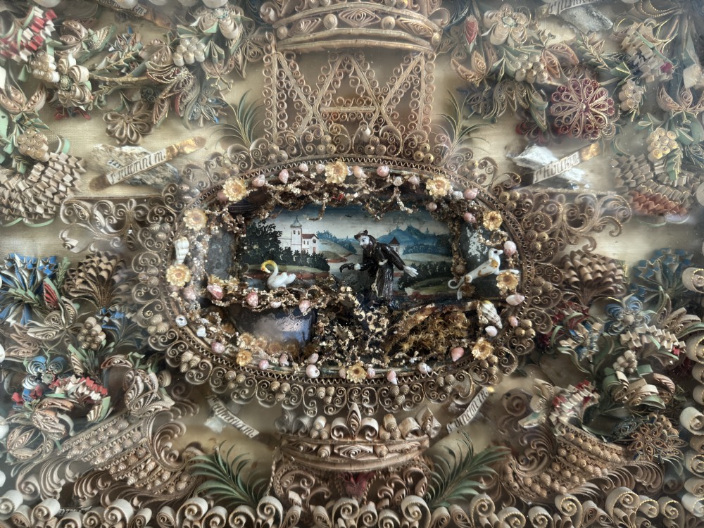 An 18th-century French giltwood framed shadow box containing intricate paperoles scrollwork surrounding a central miniature landscape with Nevers glass figures. View VIII