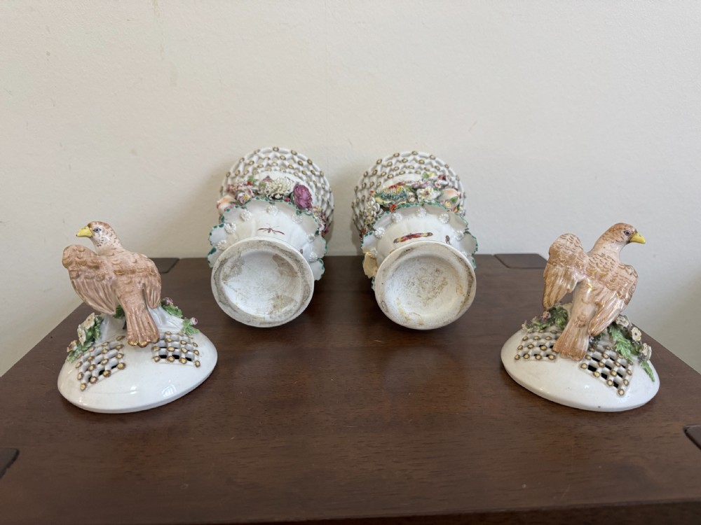 A pair of 18th-century soft-paste Derby porcelain frill vases featuring reticulated rims, hand-modelled floral encrustations, female mask appliques, painted insects, and lid finials shaped as birds. View XV