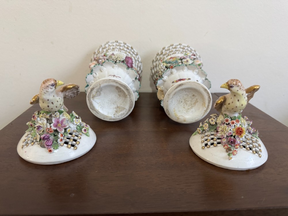 A pair of 18th-century soft-paste Derby porcelain frill vases featuring reticulated rims, hand-modelled floral encrustations, female mask appliques, painted insects, and lid finials shaped as birds. View XVII