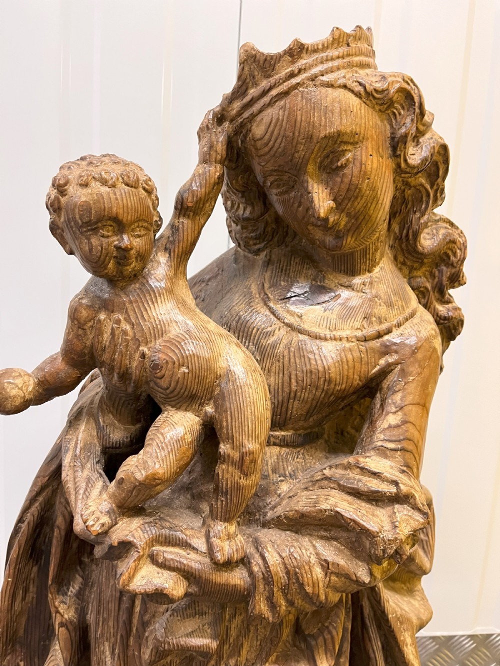 A 19th-century hand-carved wooden statue depicting the crowned Virgin Mary holding the Christ child in detailed draped robes. View II