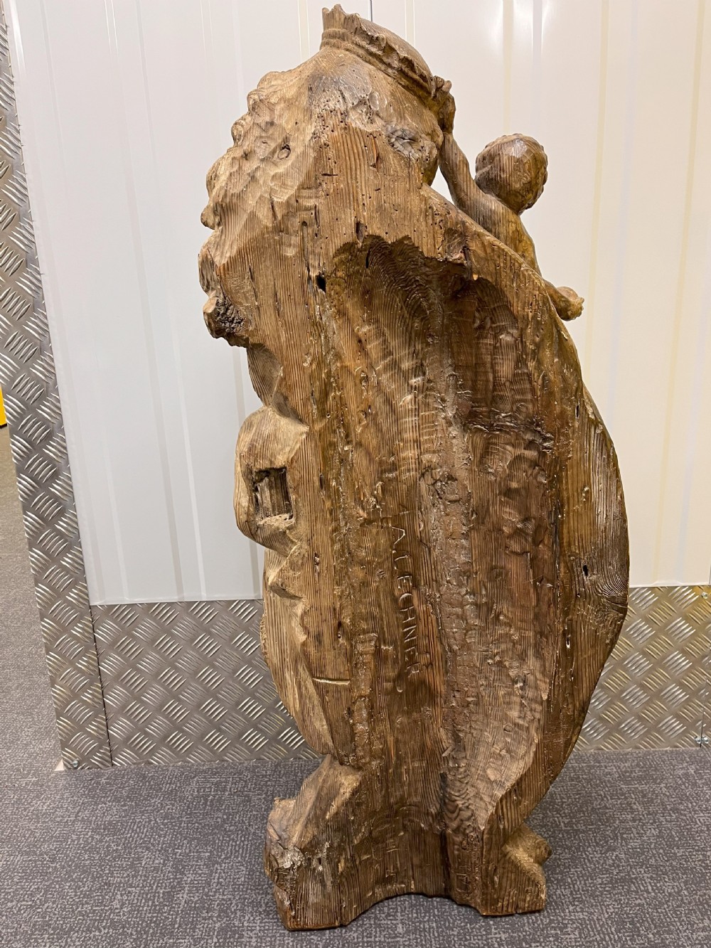 A 19th-century hand-carved wooden statue depicting the crowned Virgin Mary holding the Christ child in detailed draped robes. View V