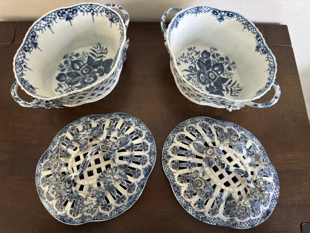A pair of 18th-century Worcester blue and white porcelain chestnut baskets with reticulated covers, twig handles, and encrusted floral decorations. View V