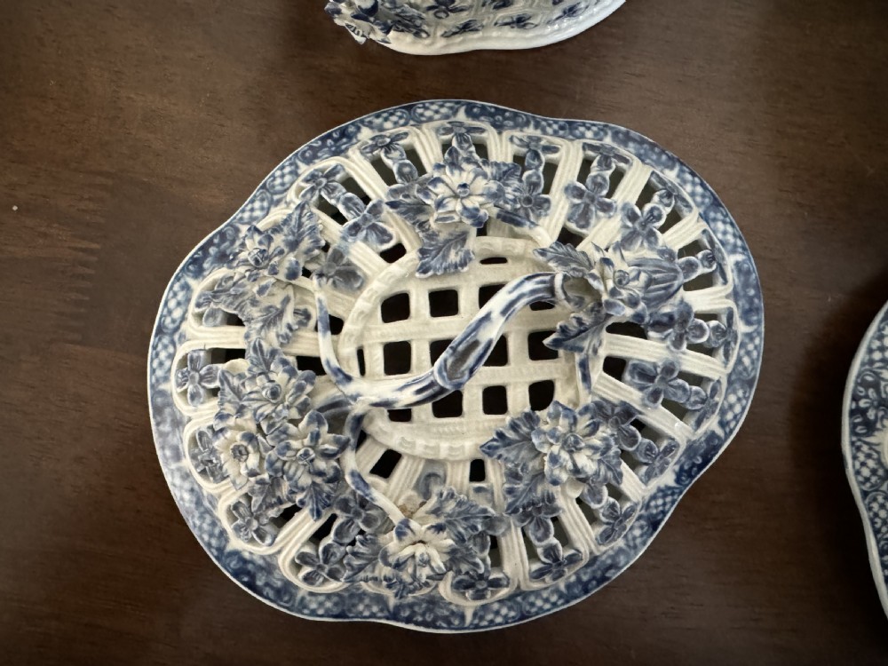 A pair of 18th-century Worcester blue and white porcelain chestnut baskets with reticulated covers, twig handles, and encrusted floral decorations. View VII