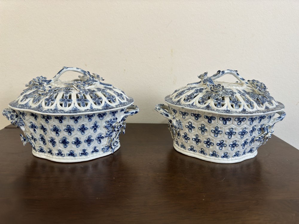 A pair of 18th-century Worcester blue and white porcelain chestnut baskets with reticulated covers, twig handles, and encrusted floral decorations. View IX