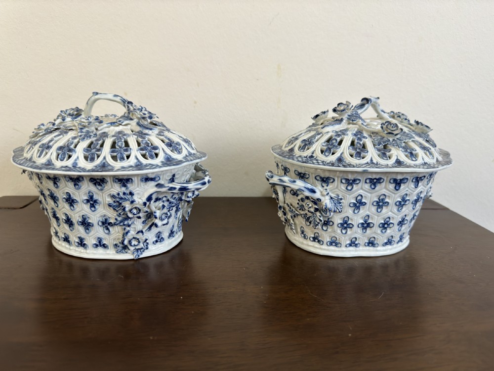A pair of 18th-century Worcester blue and white porcelain chestnut baskets with reticulated covers, twig handles, and encrusted floral decorations. View X