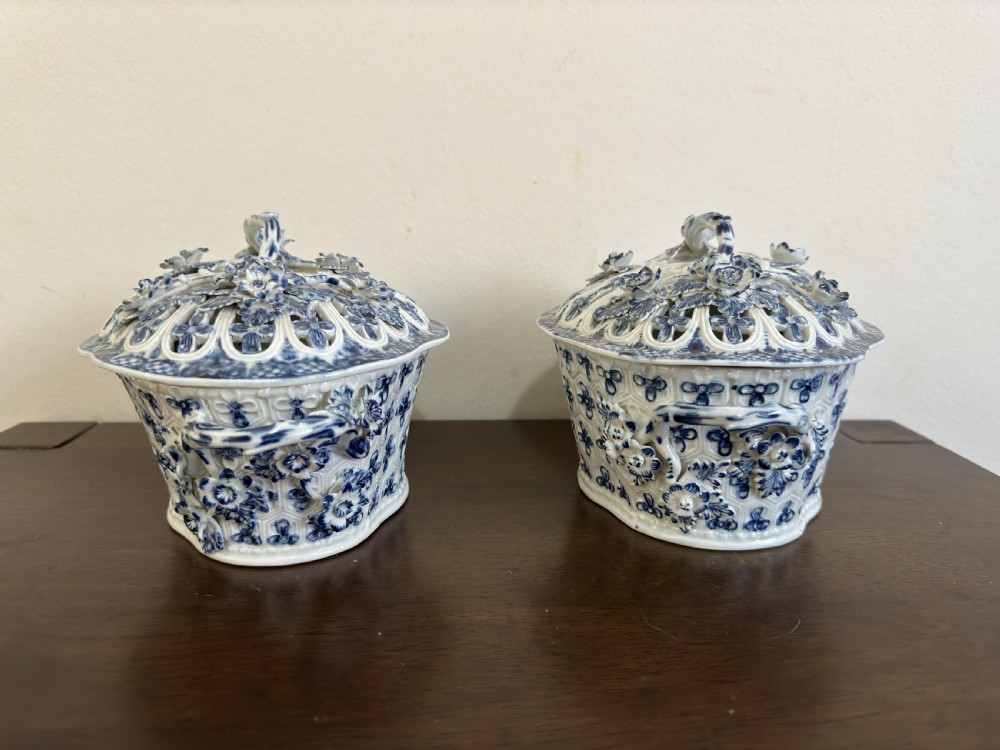 A pair of 18th-century Worcester blue and white porcelain chestnut baskets with reticulated covers, twig handles, and encrusted floral decorations. View XV