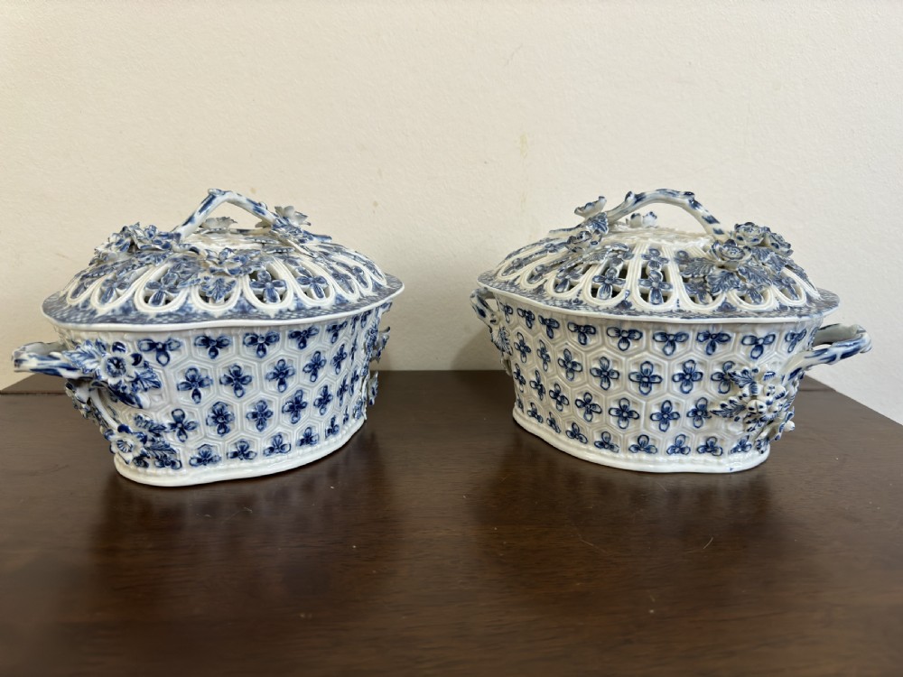 A pair of 18th-century Worcester blue and white porcelain chestnut baskets with reticulated covers, twig handles, and encrusted floral decorations. View XVI