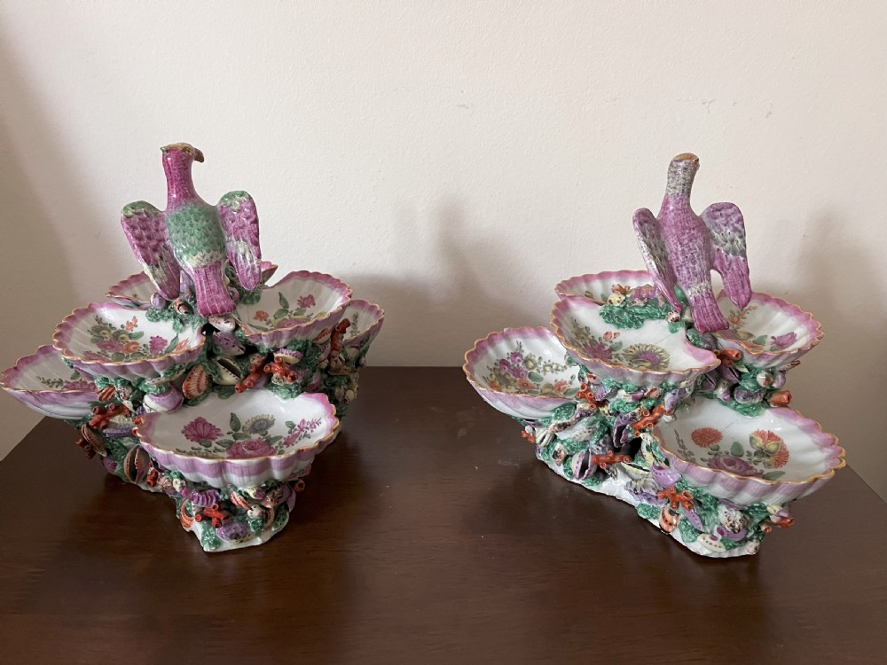 A pair of 18th-century First Period Worcester soft-paste porcelain tiered centrepieces featuring moulded shell dishes, encrusted marine decoration, and bird finials in pink and green enamels. View VI