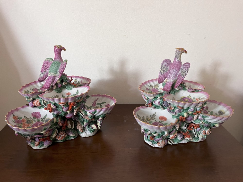 A pair of 18th-century First Period Worcester soft-paste porcelain tiered centrepieces featuring moulded shell dishes, encrusted marine decoration, and bird finials in pink and green enamels. View VII