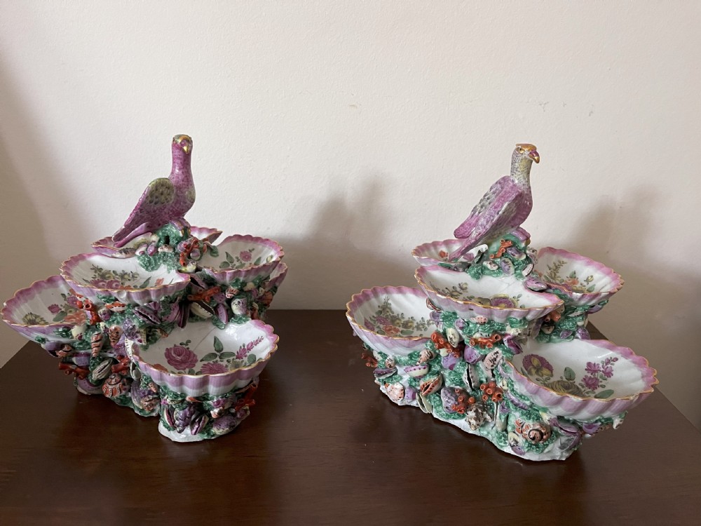 A pair of 18th-century First Period Worcester soft-paste porcelain tiered centrepieces featuring moulded shell dishes, encrusted marine decoration, and bird finials in pink and green enamels. View VIII