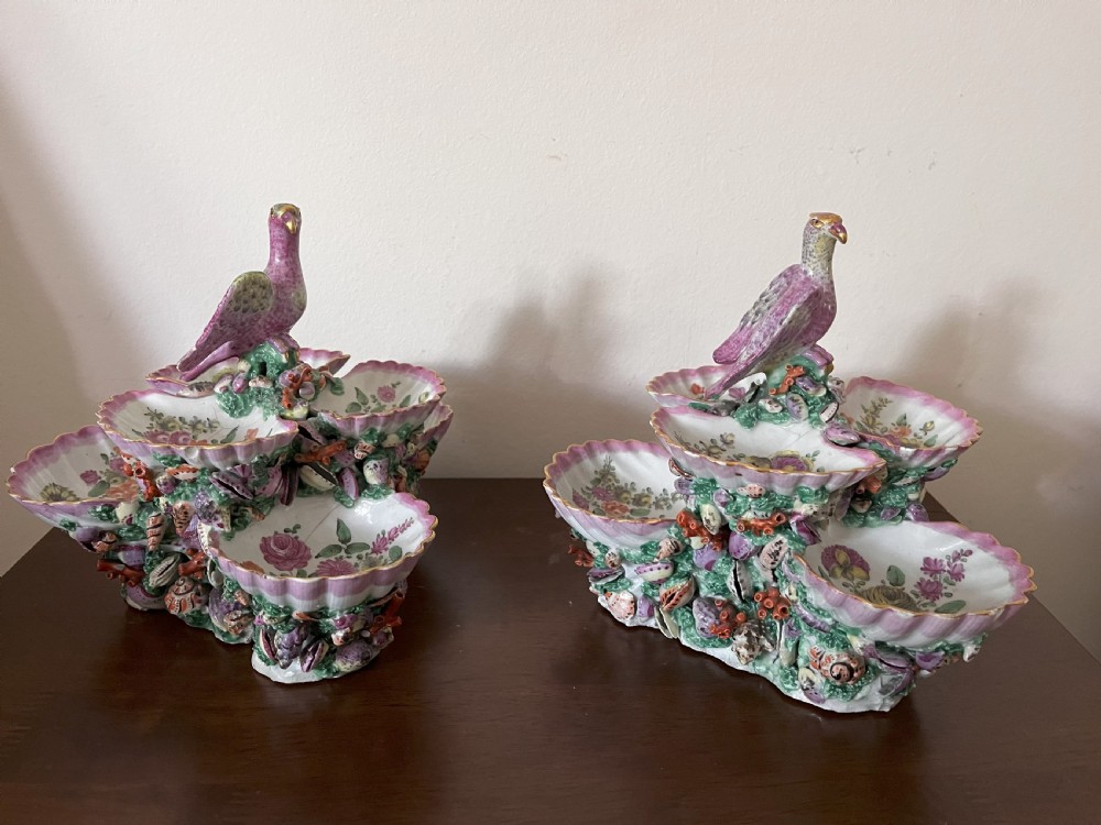 A pair of 18th-century First Period Worcester soft-paste porcelain tiered centrepieces featuring moulded shell dishes, encrusted marine decoration, and bird finials in pink and green enamels. View IX