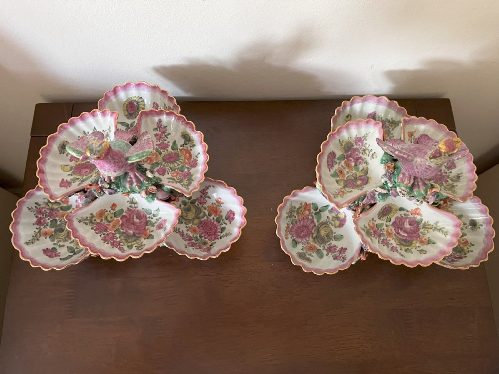 A pair of 18th-century First Period Worcester soft-paste porcelain tiered centrepieces featuring moulded shell dishes, encrusted marine decoration, and bird finials in pink and green enamels. View XI