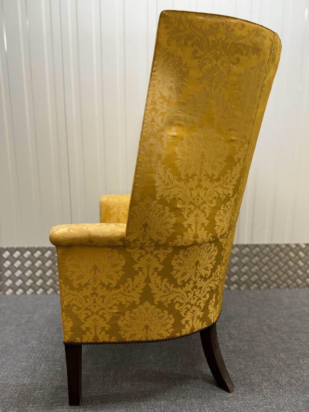 A Georgian mahogany wingback armchair featuring yellow damask patterned upholstery, a channel-fluted backrest, and straight dark wood legs. View V