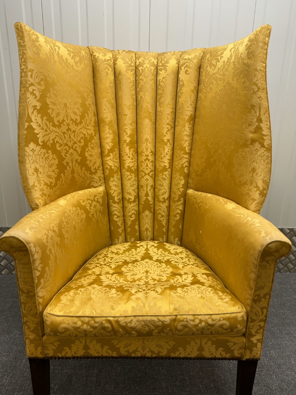 A Georgian mahogany wingback armchair featuring yellow damask patterned upholstery, a channel-fluted backrest, and straight dark wood legs. View VI