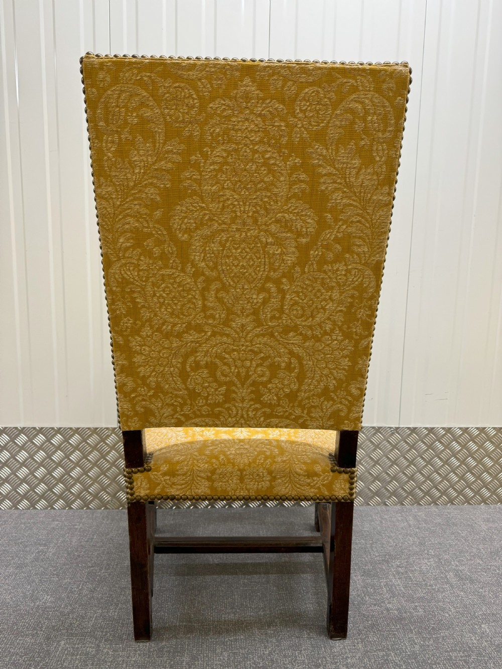 An antique Charles II style walnut elbow chair featuring turned wood legs, scrolled armrests, brass stud details, and yellow damask upholstery. View III