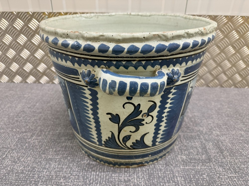 An 18th-century French Nevers faience ceramic orange pot decorated with hand-painted cobalt blue landscape motifs, geometric borders, and twin side handles. View V