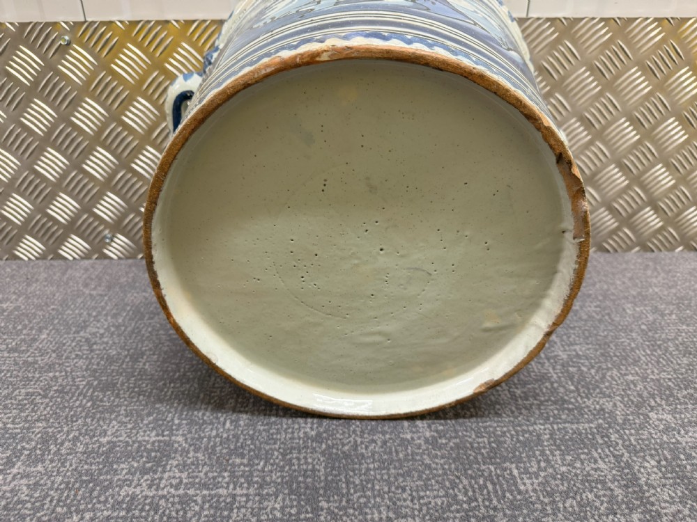 An 18th-century French Nevers faience ceramic orange pot decorated with hand-painted cobalt blue landscape motifs, geometric borders, and twin side handles. View VII