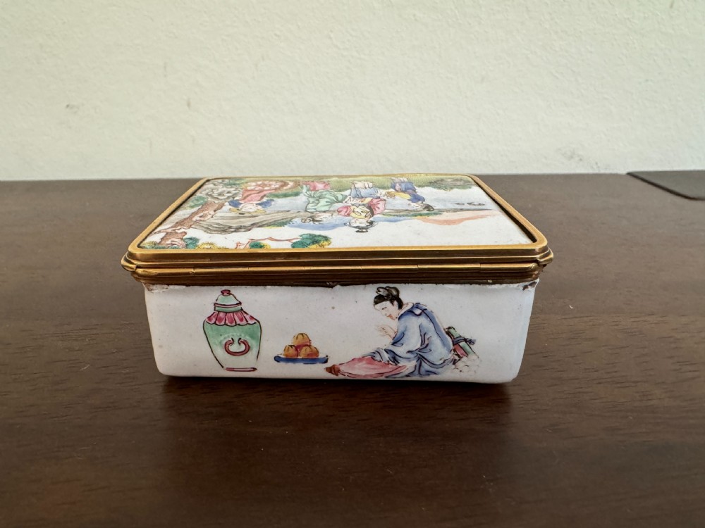 A rectangular 18th-century Chinese Beijing enamel snuff box decorated with a hand-painted scene of figures in traditional attire beside a river and framed by gilded metal. View IV