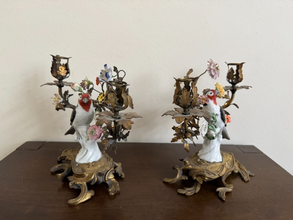 A pair of nineteenth-century French ormolu candelabra featuring hand-painted porcelain birds surrounded by gilt branches and floral mounts. View X