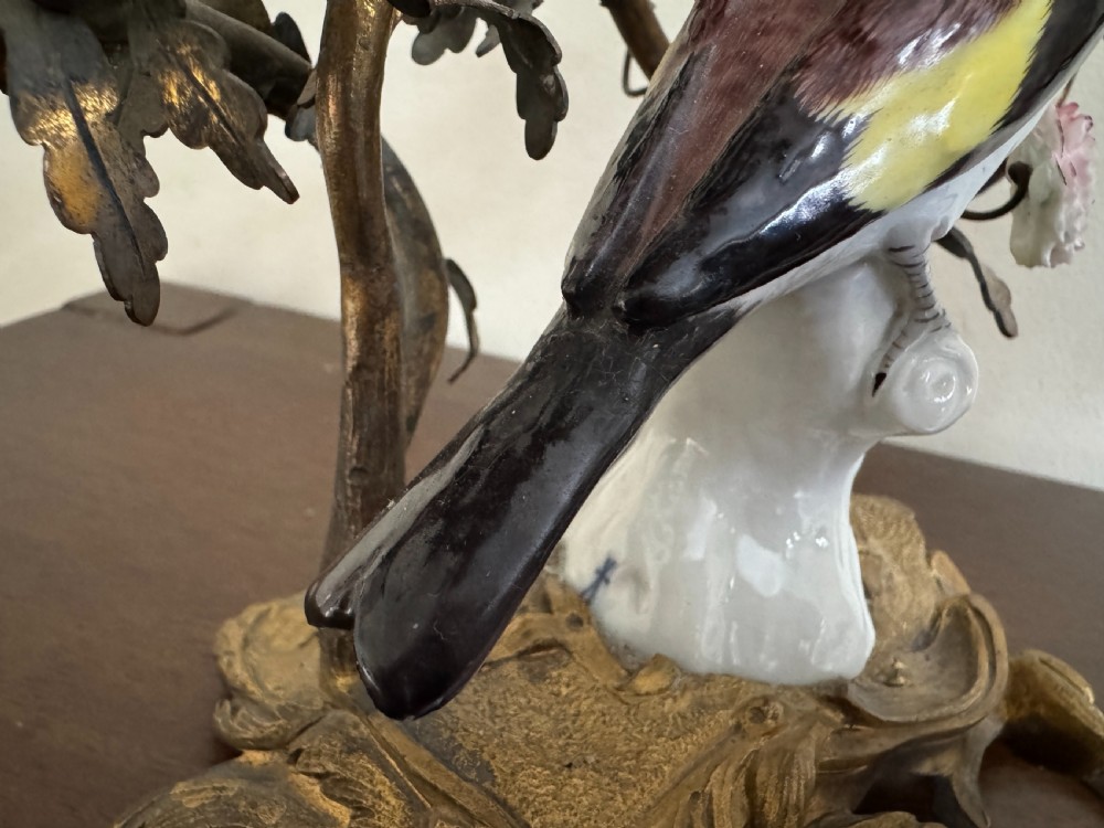 A pair of nineteenth-century French ormolu candelabra featuring hand-painted porcelain birds surrounded by gilt branches and floral mounts. View XVI