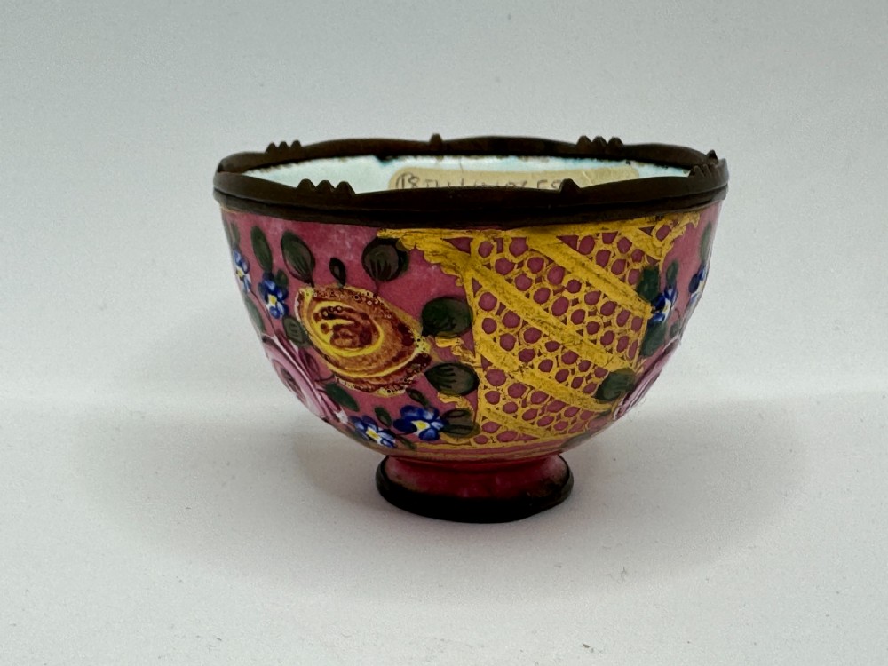 An 18th-century Limoges enamel salt bowl featuring hand-painted floral motifs on a pink ground with gilt lattice detailing and a dark metal rim. View VI