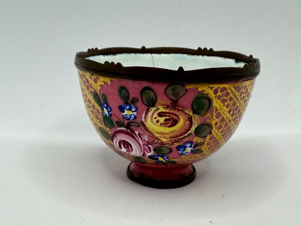 An 18th-century Limoges enamel salt bowl featuring hand-painted floral motifs on a pink ground with gilt lattice detailing and a dark metal rim. View VII
