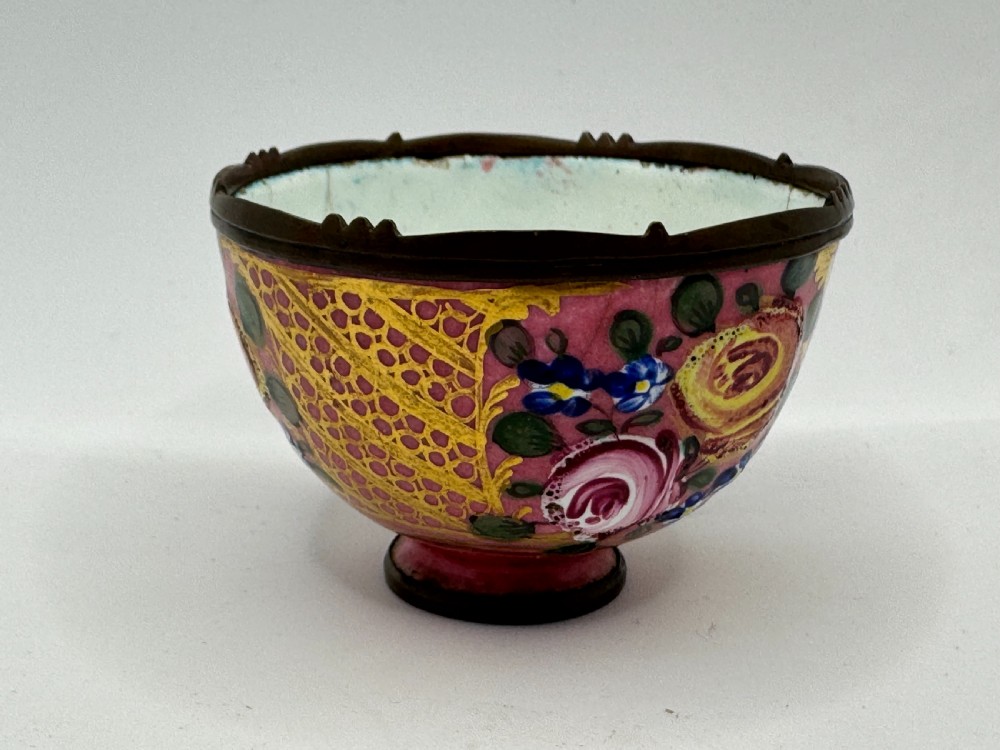 An 18th-century Limoges enamel salt bowl featuring hand-painted floral motifs on a pink ground with gilt lattice detailing and a dark metal rim. View IX