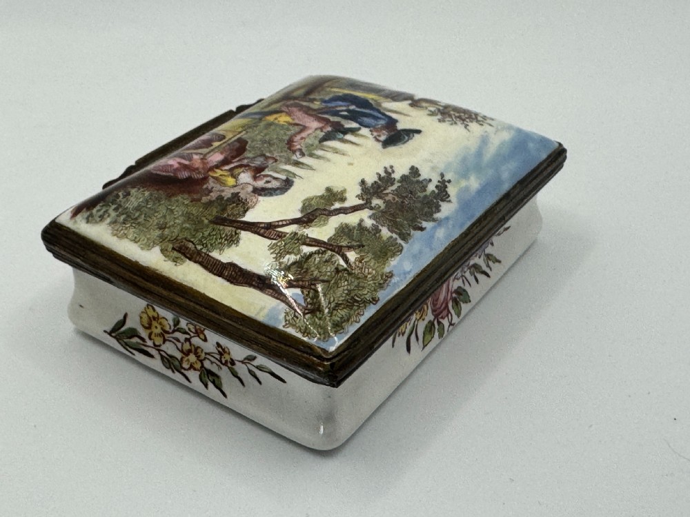 A rectangular 18th-century Bilston enamel box decorated with a painted pastoral scene on the lid and floral sprigs along the white base. View VII