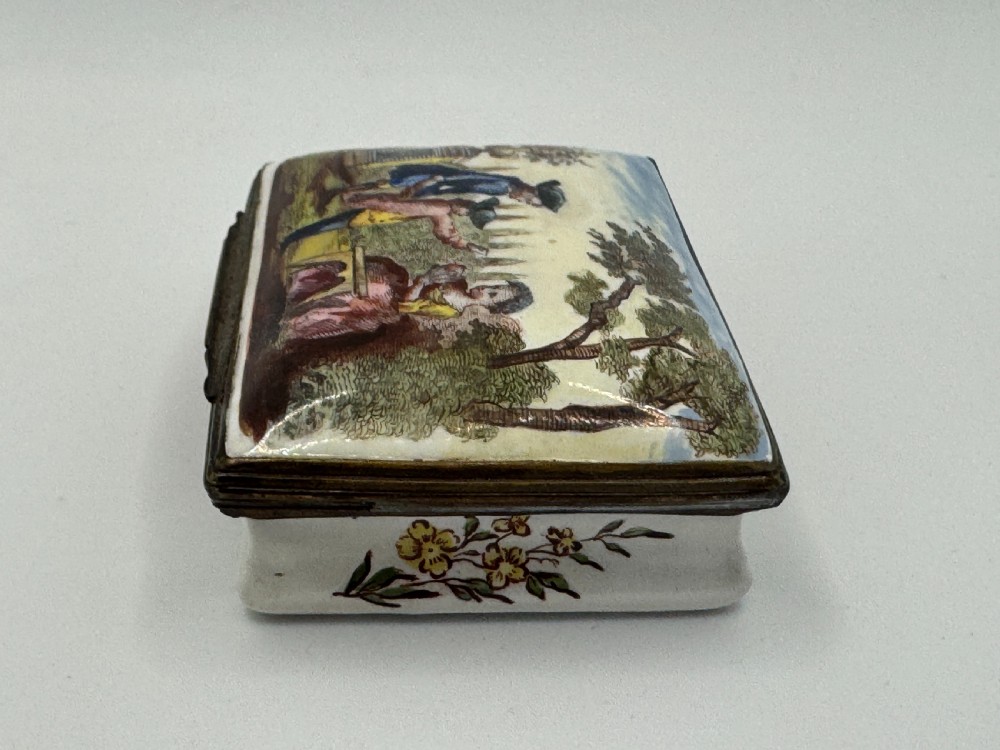 A rectangular 18th-century Bilston enamel box decorated with a painted pastoral scene on the lid and floral sprigs along the white base. View VIII