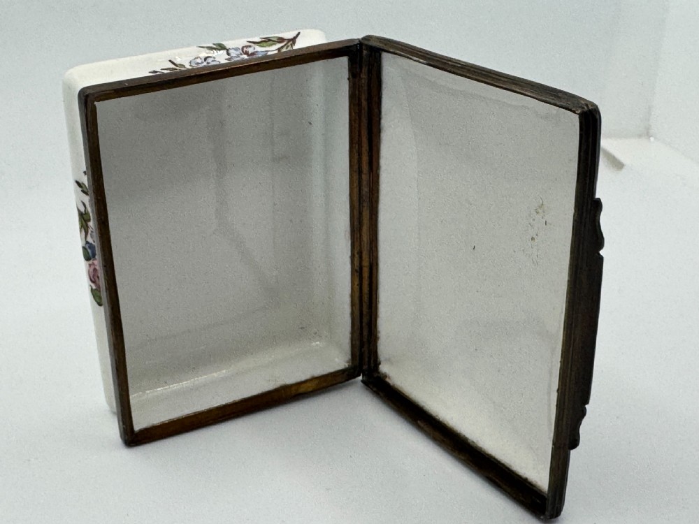 A rectangular 18th-century Bilston enamel box decorated with a painted pastoral scene on the lid and floral sprigs along the white base. View XV